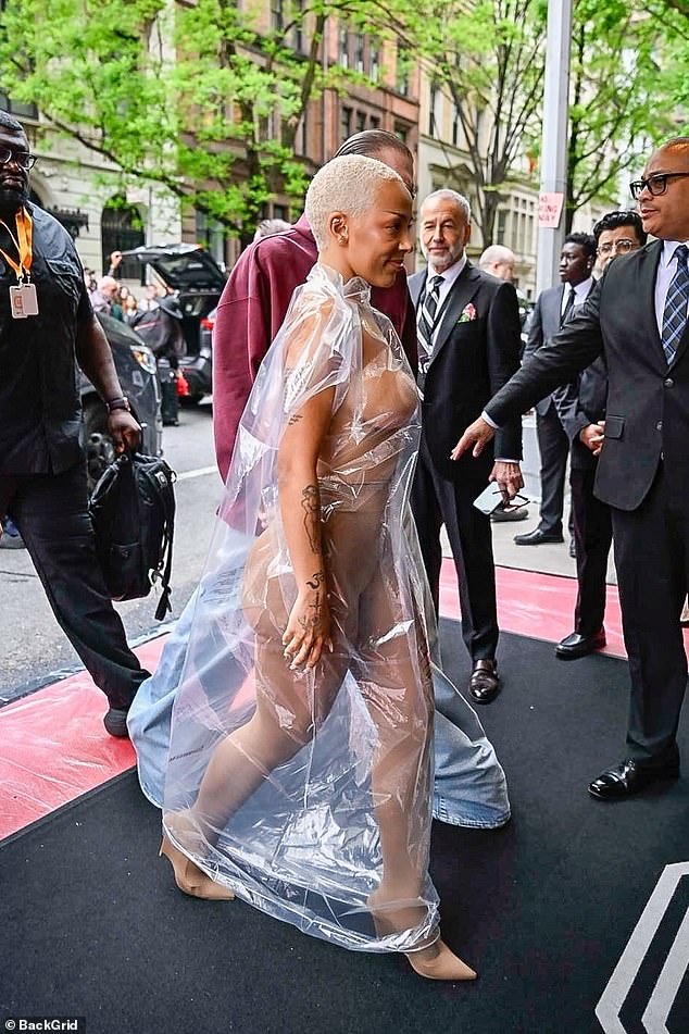 She sported a sheer poncho, which looked like a shower curtain and/or a puffy hat, over a nude catsuit.