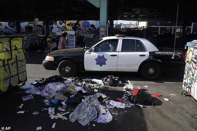 A San Francisco Police Department vehicle drives through a homeless encampment being cleared in San Francisco.