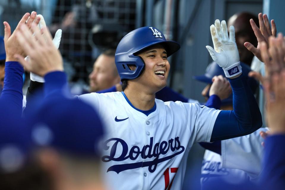 Dodgers star Shohei Ohtani celebrates in the dugout after hitting a two-run home run in the first inning on Monday.