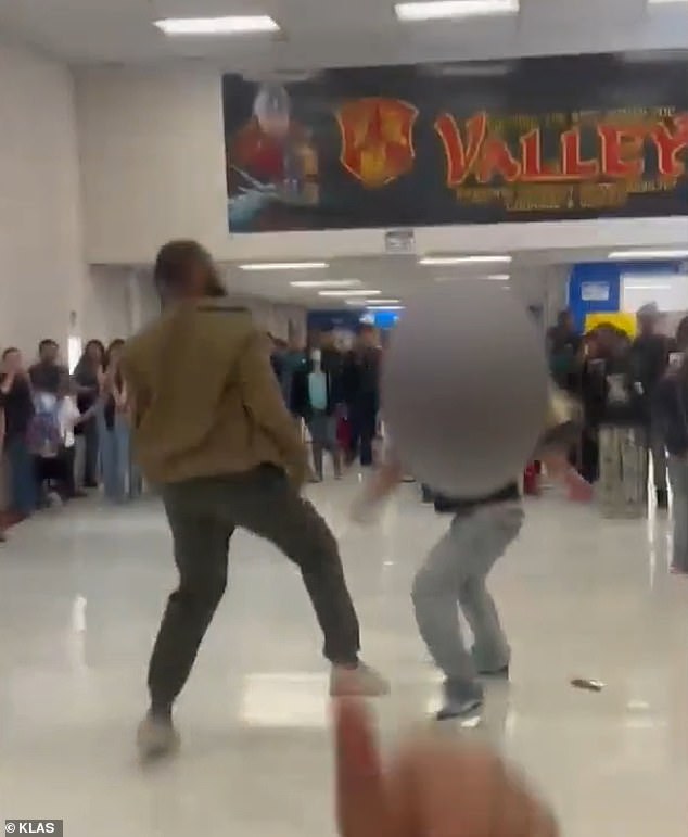 It shows the rookie substitute exchanging blows with the unnamed student in the school hallways, while a crowd of children surrounds them.