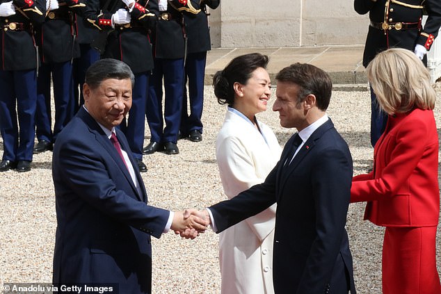 Xi Jinping arrives at the Elysee Palace to meet Emmanuel Macron, while their wives shake hands on the red carpet