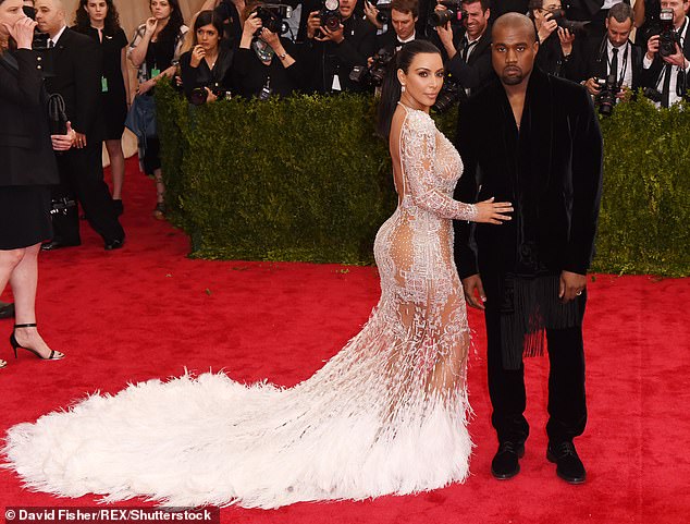 In 2015, Kim wore a stunning semi-sheer white dress with a long, feathery white train, and Kanye wore an all-black suit.