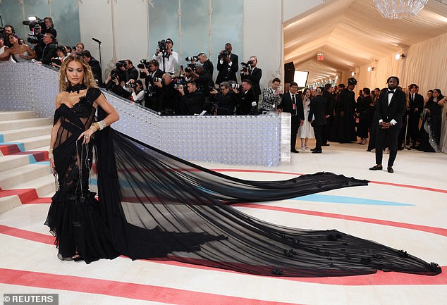 Her barely-there dress had floral lace appliqués and perfectly placed chiffon, while her train floated seemingly for miles behind her and down the iconic steps.