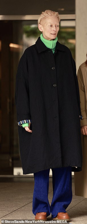 Swinton slipped her slim 5ft 11in frame into a green turtleneck, blue wide-leg jeans, brown loafers and a black winter coat.