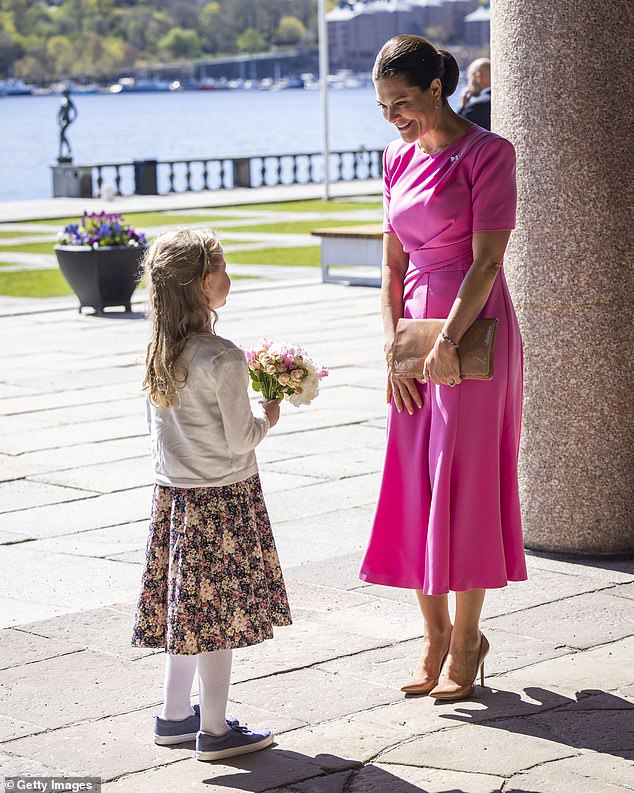 The royal looked bright and cheerful in the short-sleeved pink dress that cinched at the waist.