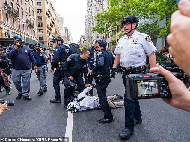 A protester is detained on the street during demonstrations in New York