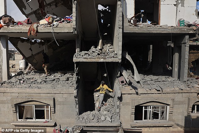 A young Palestinian inspects the damage inside a building destroyed after the Israeli bombardment of the Tal al-Sultan district of Rafah, southern Gaza Strip, on May 7, 2024.