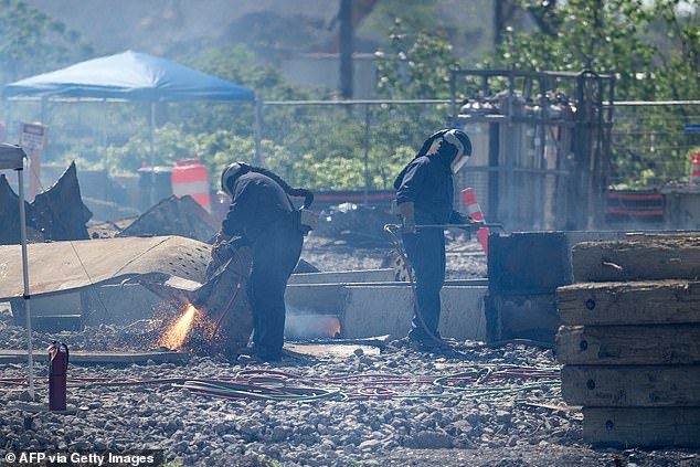 Workers cut up stolen parts of the Key Bridge for recycling after the freighter Dali crashed and collapsed at the Patapsco River entrance to the Port of Baltimore.