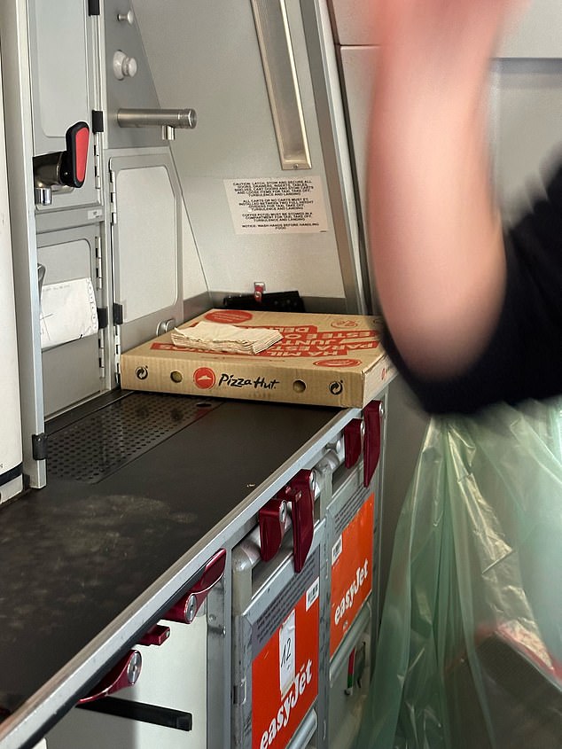 An image sent to MailOnline shows a pizza box placed on a shelf in the crew area of ​​the plane after it was delayed so the crew could get food for the flight from Lisbon to Manchester.