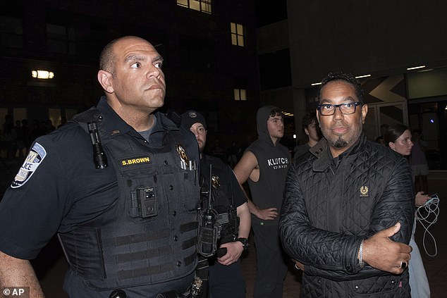 Christopher Bracey, who faced calls to face the guillotine this week, is seen with campus police on April 28 after protesters broke into a building he was in.