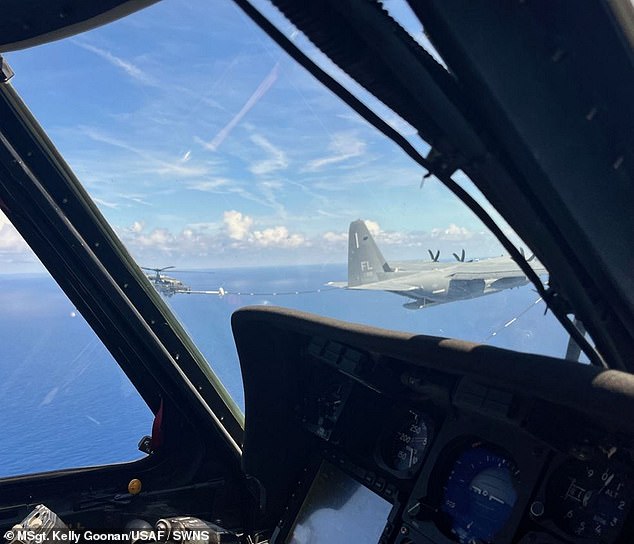 An HH-60G Pave Hawk helicopter receives fuel from an HC-130J Combat King II during a civilian medical airlift operation of a critical patient aboard a cruise ship more than 350 miles off the U.S. East Coast.