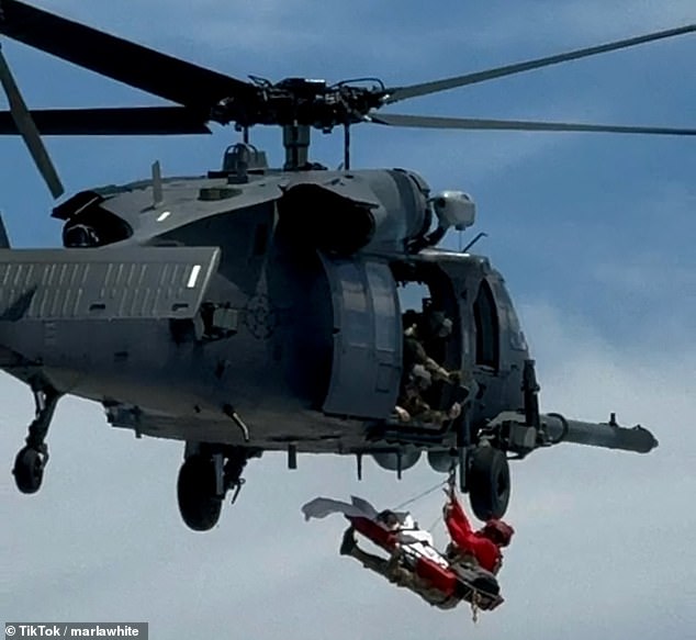 The paratroopers were lowered from the helicopter to help the critical cruise ship passenger.