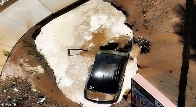 The water turned the terrain swampy, opening a sinkhole that then engulfed one of the cars.