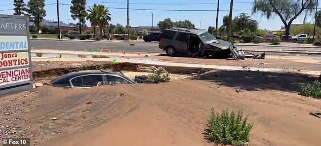 The car on the side of the road slowly disappeared from sight as it was sucked beneath the surface of the muddy water and ground.