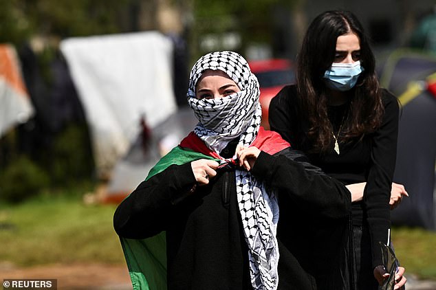 Pro-Palestinian protesters cover their faces outside the Oxford University Museum of Natural History