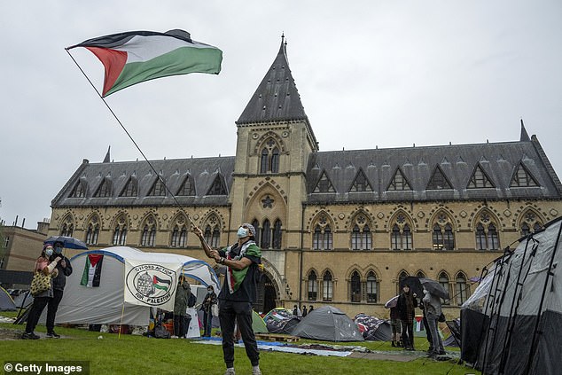 A student activist waves a Palestinian flag at a pro-Palestinian camp at Oxford University on May 6, 2024.