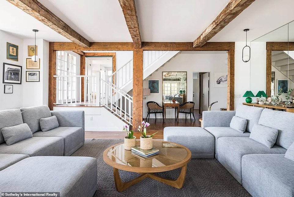 A large living room on the ground floor not only has exposed beams but also a set of matching door panels, amplifying the bucolic atmosphere.