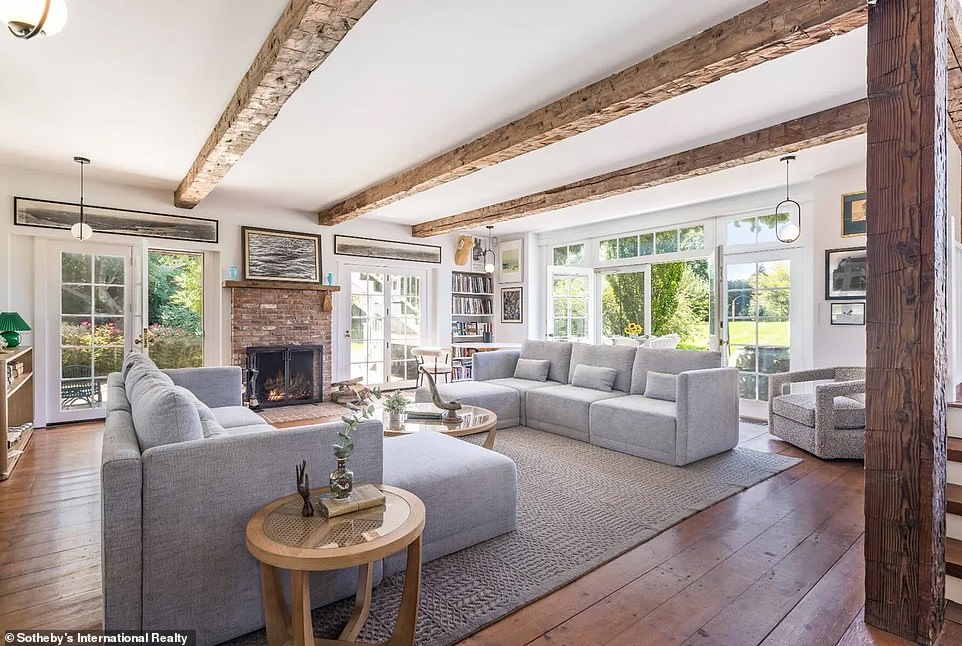 At one end of that living room is a fully functional fireplace, framed by an antique brick surround topped with a wood mantel.