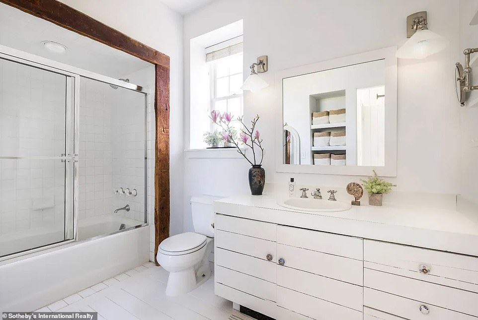 One of the bathrooms has been designed with the same motif as the large living room on the ground floor: white dotted with exposed wood.