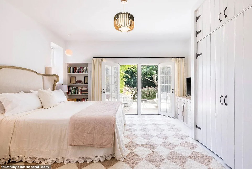 In the guest house, the bedroom features a rug with an elegant white and pink argyle print, which is currently complemented by the bedding.