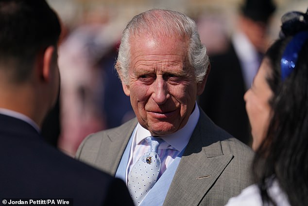 King Charles III speaks to guests attending the Buckingham Palace garden party today