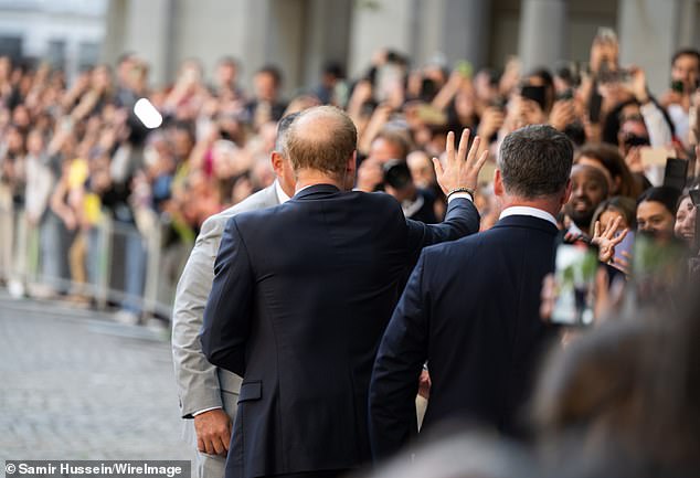 Prince Harry waves to fans waiting to greet him outside St Paul's Cathedral yesterday