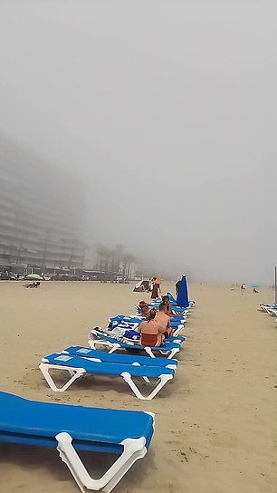 Tourists were left baffled when a Benidorm beach disappeared in thick fog, prompting Brits to return home to bask in sunny 23-degree weather.