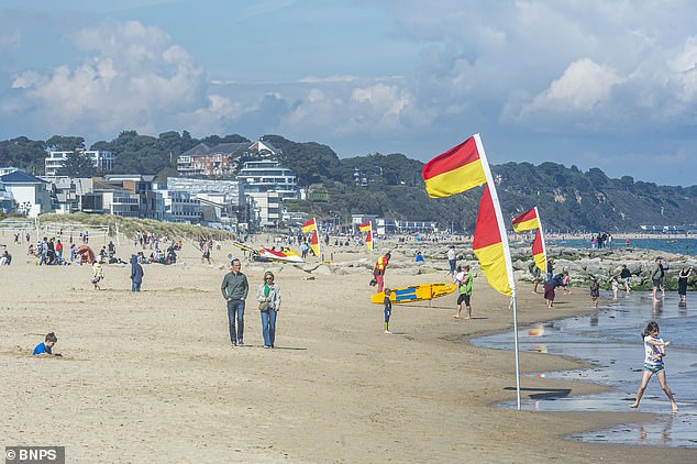 People enjoy a warm sunny day on Sandbanks beach, Dorset, over the bank holiday weekend