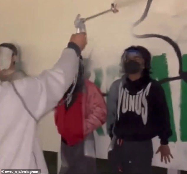 The video shows a white wall in an area outside the university that has been vandalized with pro-Gaza symbols, doodles and phrases.