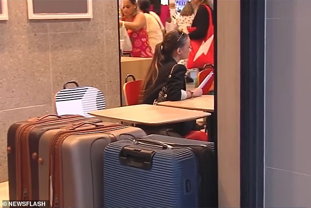 The women stay at the fast food restaurant all day with at least five large suitcases.