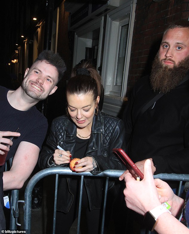 At one point, the actress was seen autographing an apple, before smiling at fans for photos.