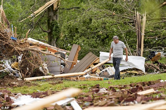 Tennessee resident John Bernhardt searches for his belongings outside his home damaged by the break-in Thursday.