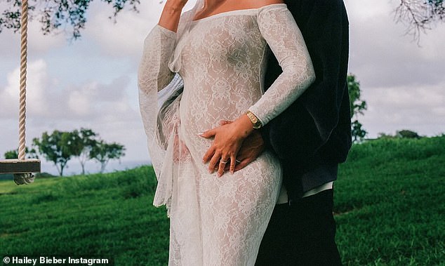 Hailey showed off her baby bump in her wedding dress while Justin hugged her.