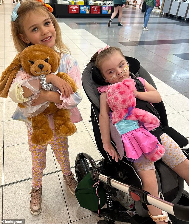 Koa (pictured with her older sister Ava) was diagnosed with a rare, incurable neurological disease called lissencephaly when she was just five weeks old.