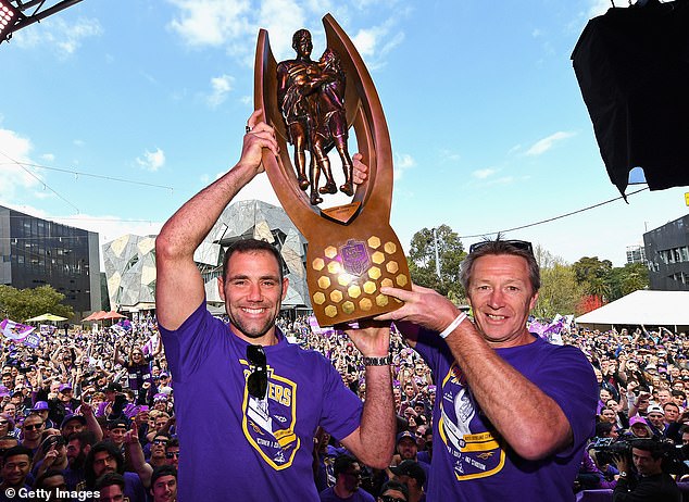 Bellamy (right) lifts the 2017 NRL premiership trophy with then captain Cameron Smith