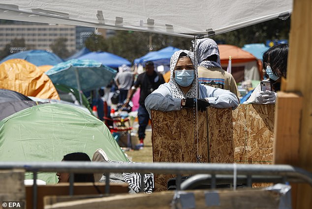 A person stands among tents set up at a camp of pro-Palestinian protesters on the UCLA campus.