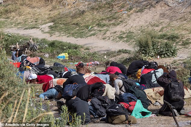 The Texas National Guard is conducting an operation using non-lethal weapons, specifically a pepper spray gun, to disperse migrants maintaining a camp within the Rio Grande.