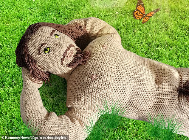 Here, the knitted doll appears to be lying casually on the grass.