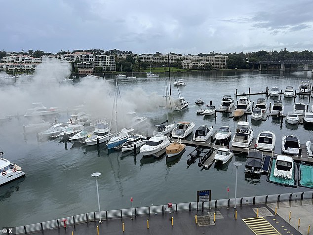 Black smoke billows from the wrecked yacht which was parked just off Drummoyne, near Birkenhead Marina, when it caught fire at around 10am