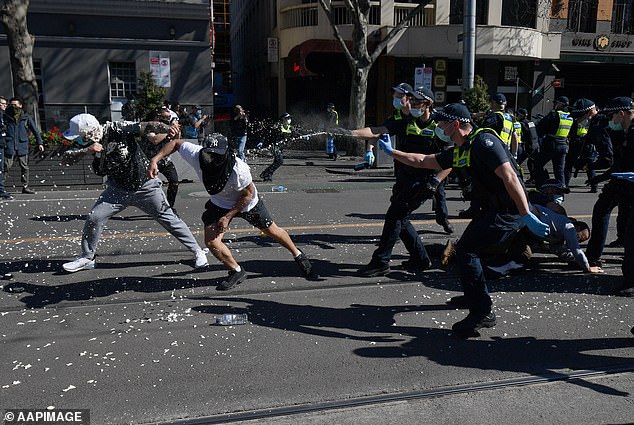 Protesters are pictured being pepper sprayed at an anti-lockdown protest in Melbourne.