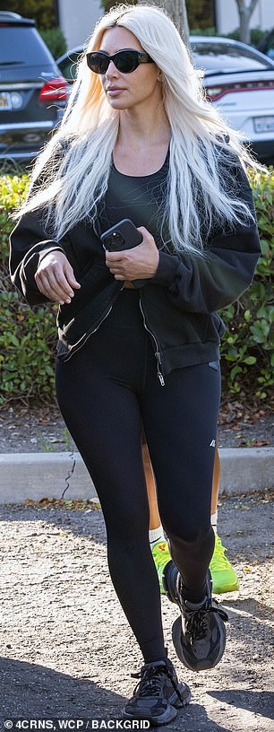 Protecting herself from the cold with a black jacket, she completed the ensemble with a pair of sunglasses and matching sneakers.