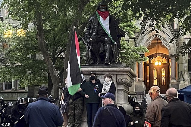 Protesters gather at the Ben Franklin statue on Penn's campus as police clear the site.