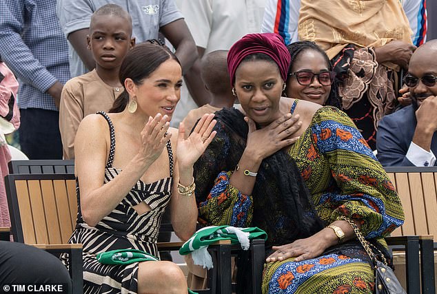 Meghan appeared in close conversation with her hosts as she watched Harry play, with a big smile.