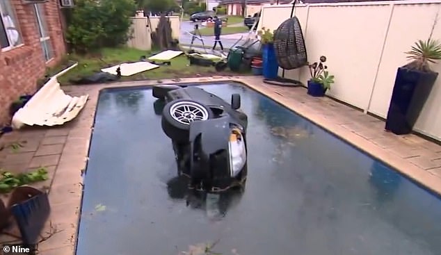 The hatchbank is seen on its side in the family's swimming pool after crashing into the rear fence.