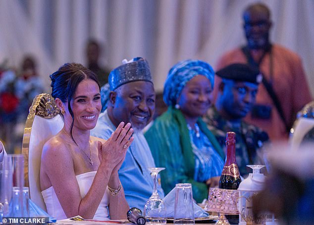 Meghan claps and laughs as she joins Nigeria's defense minister at lunch.