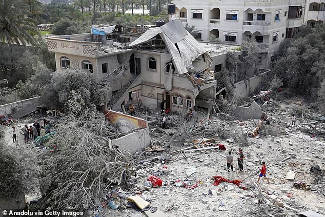 Palestinians inspect destroyed buildings in the Ez-Zawayda area after the Israeli attack in the central part of Gaza against the town of Ez-Zawayda and the Nuseirat refugee camp.