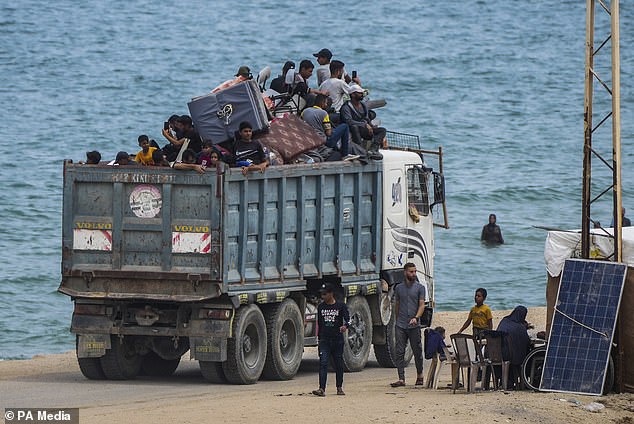 Displaced Palestinians arrive at a makeshift camp west of Rafah