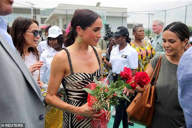 Meghan pictured carrying flowers when attending sitting volleyball match