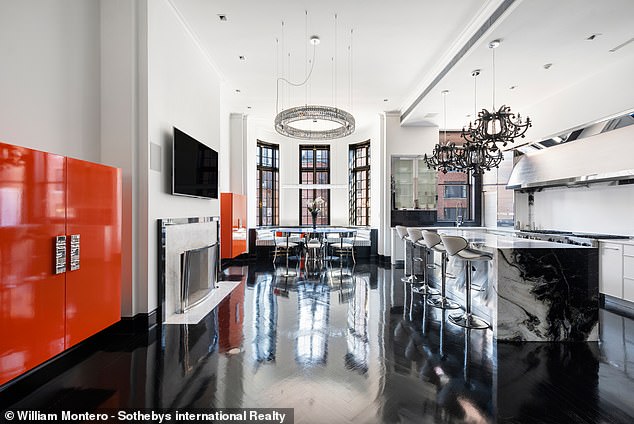 In the kitchen, an explosion of orange breaks up the black and white color scheme.