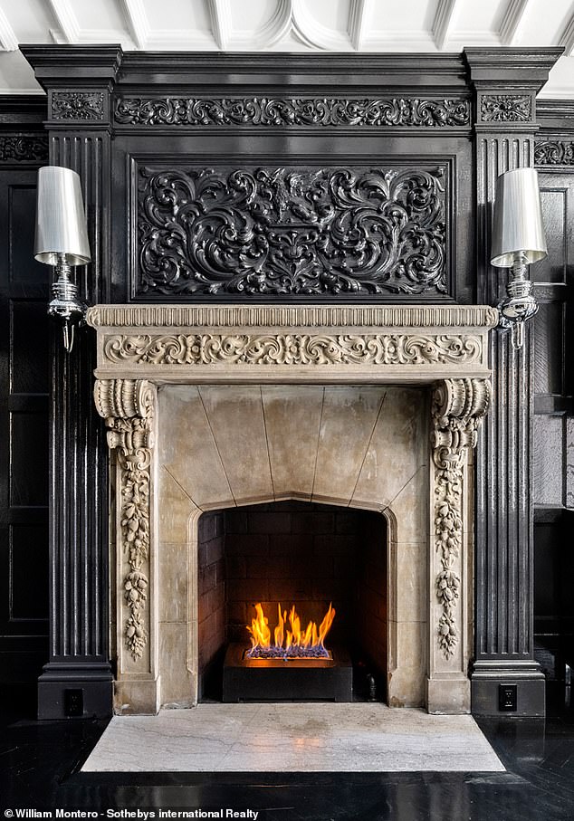 Intricate wood carvings and moldings sit above a fireplace